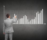startup growth strategy - man writing bar graph on chalkboard