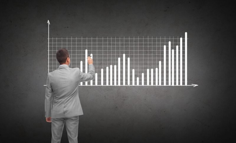 startup growth strategy - man writing bar graph on chalkboard