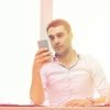 man looking at mobile app and writing business plan